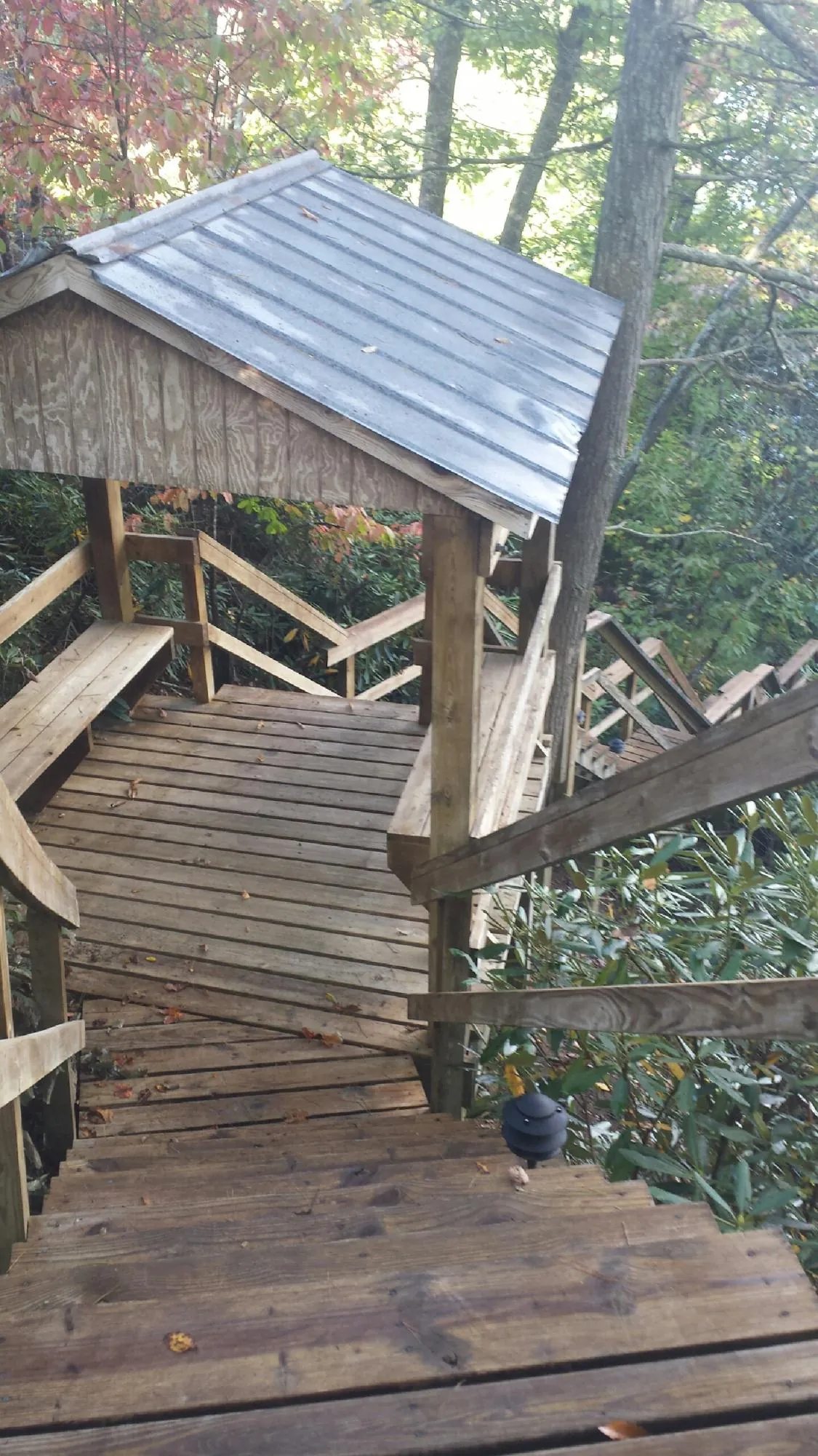 Metal roofed shelter over wooden steps on a wooded walkway — Skylight Repair & Installation work by our crew in Catskill